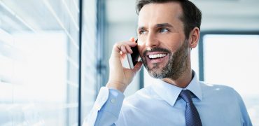 Smiling executive talking on the phone in his office Smiling executive talking on the phone in his office