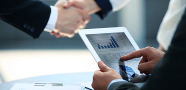 Business associates shaking hands in office